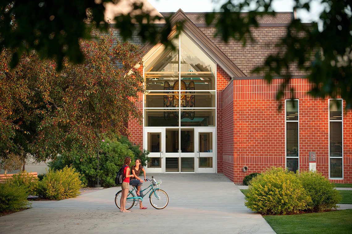 Two girls talking outside a building on the Dordt College campus in Iowa.