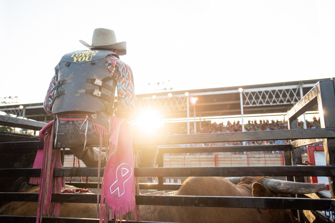 Editorial photography of a bullrider sitting on gate at rochester mn rodeo